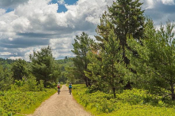 Cyclists on the open Old Rail Trail in Algonquin under a big sky