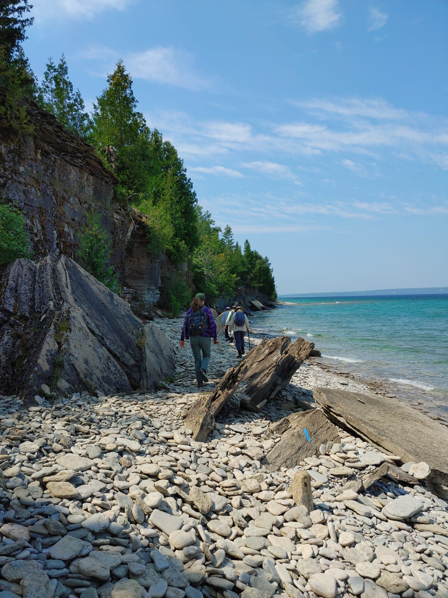 Hikers on the shoreline below the Niagara Escarpment