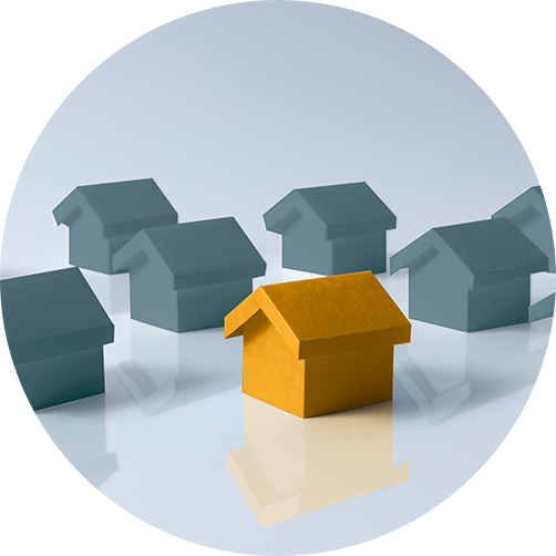 One yellow 3D house model stands out among several gray house models on a reflective surface.