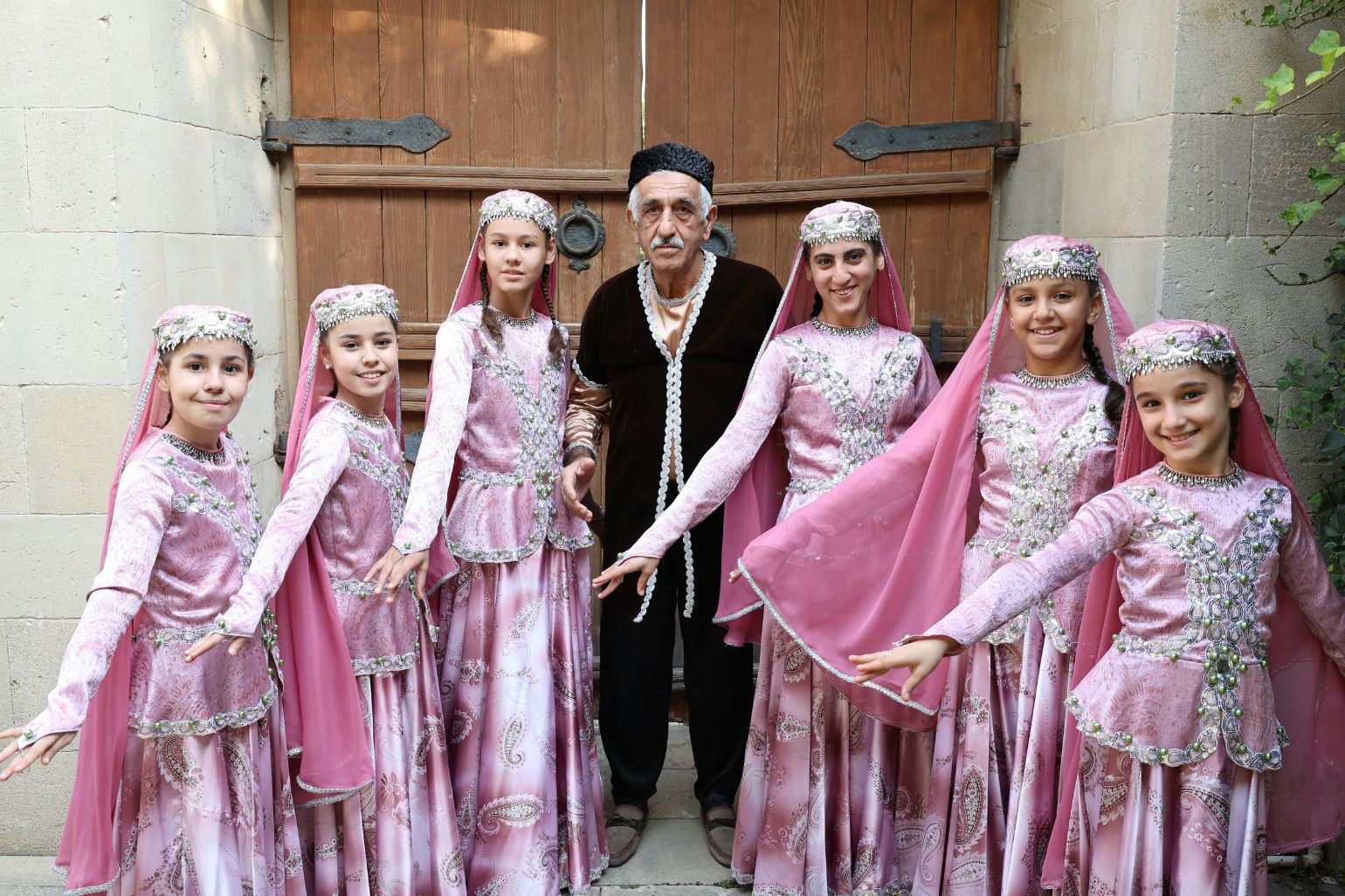 Cultural group in traditional attire representing intergenerational heritage.