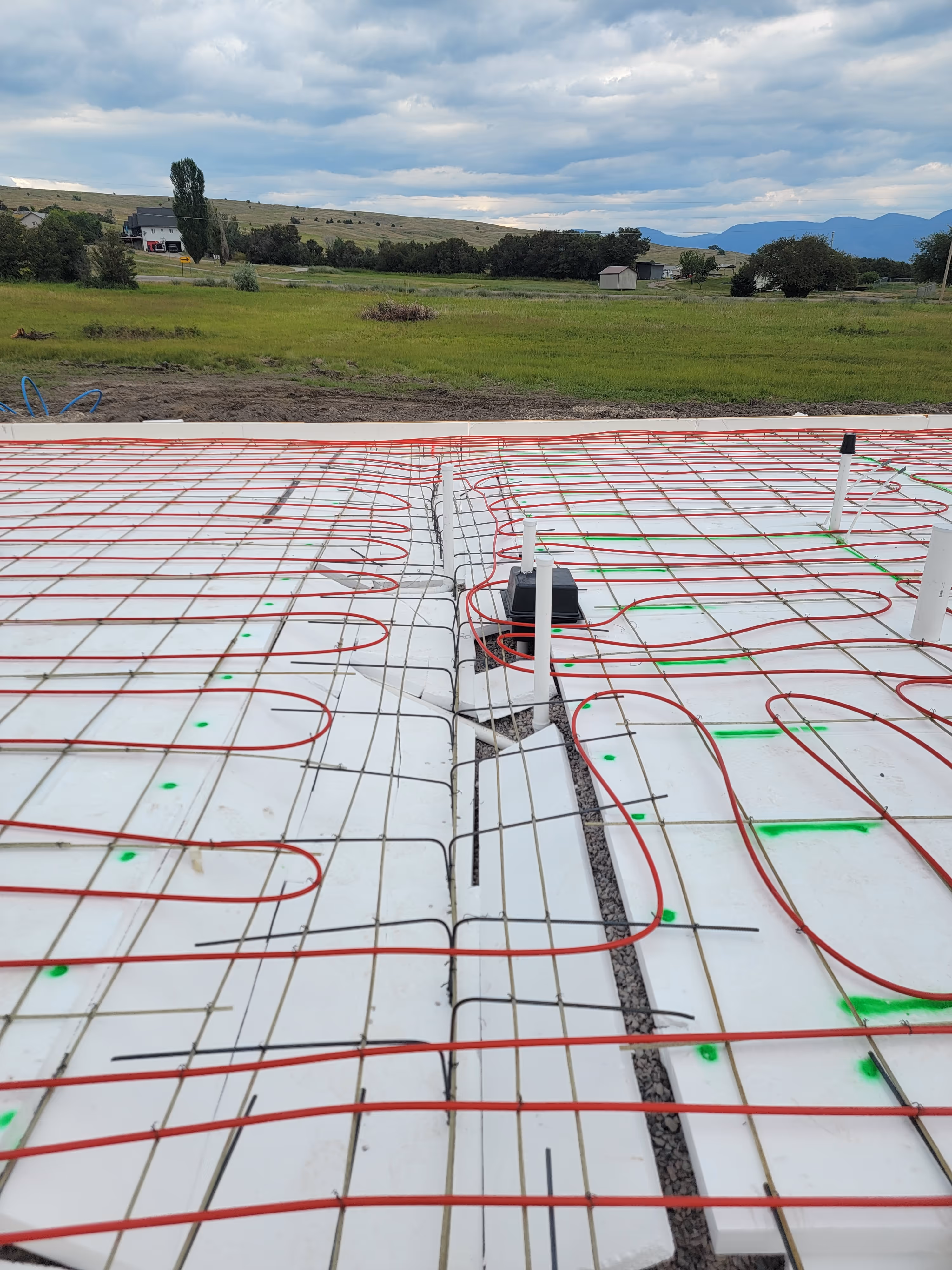 Radiant heating pipes laid out on white mesh before concrete floor pouring