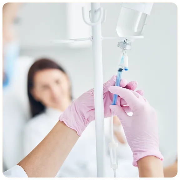 Nurse administering an infusion treatment to a patient in a clinical setting.