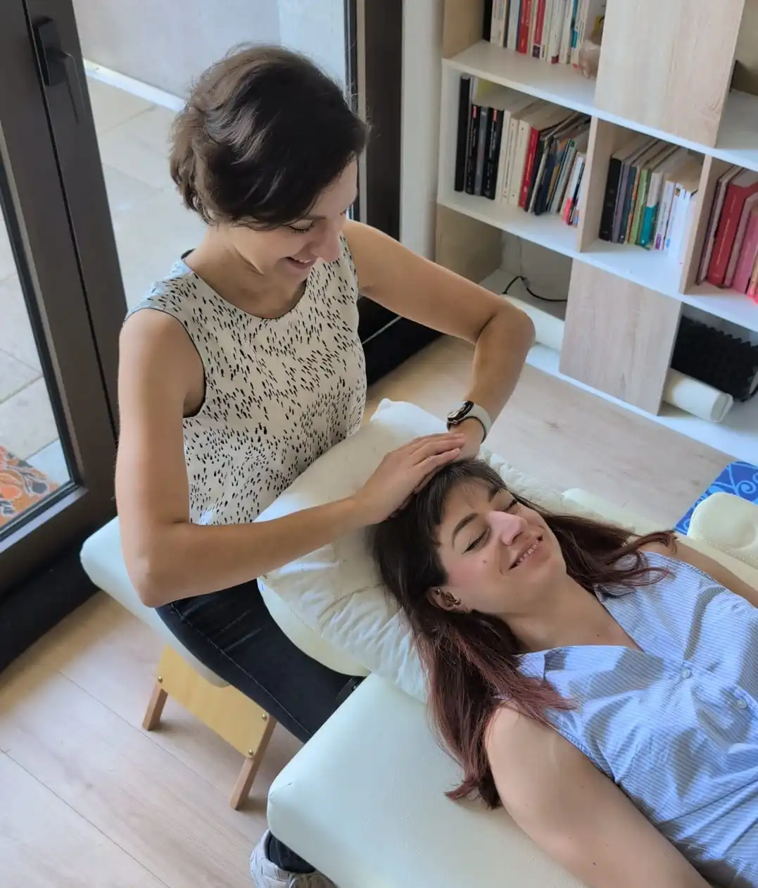 Une femme profite d'une séance de soin énergétique Reiki en étant allongée sur une table de massage
