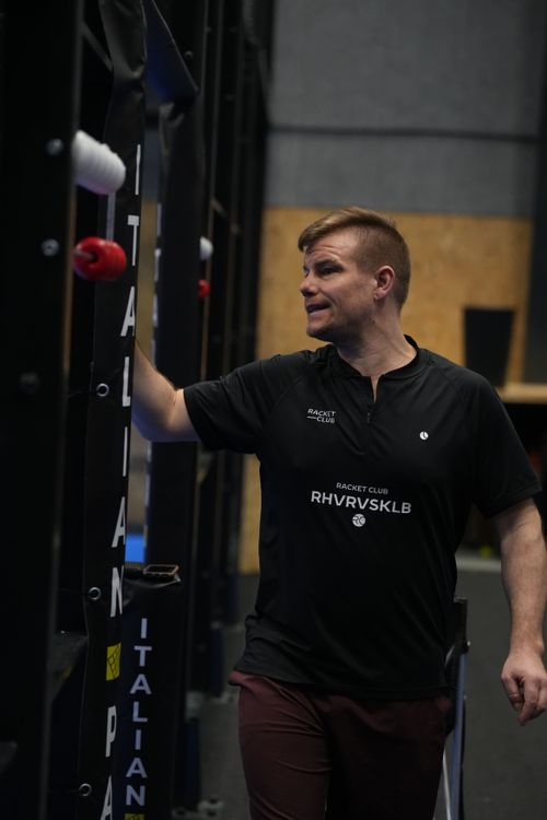 Female padel player sitting on clay coloured padel court