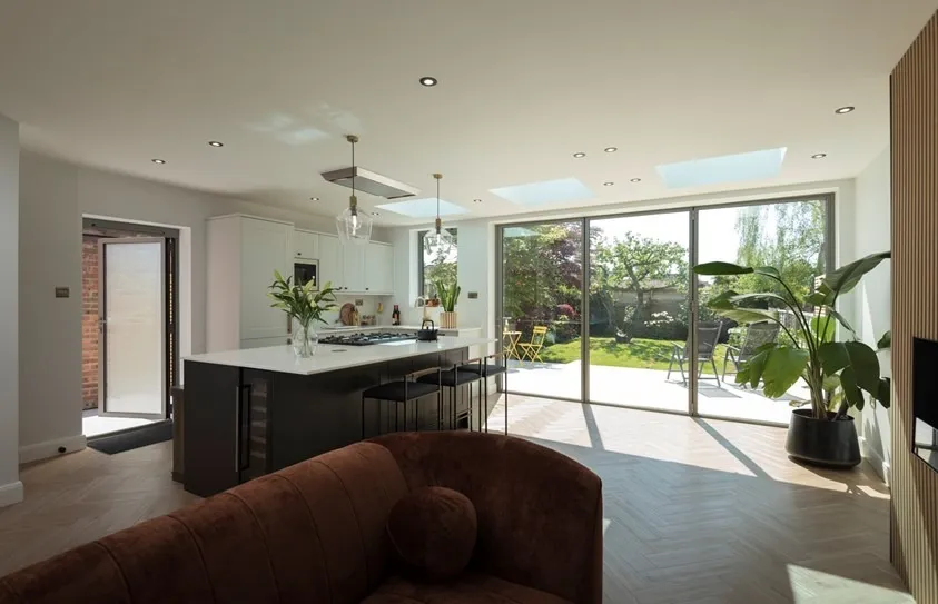 Modern open kitchen and living area large glass sliding doors opening to a garden patio