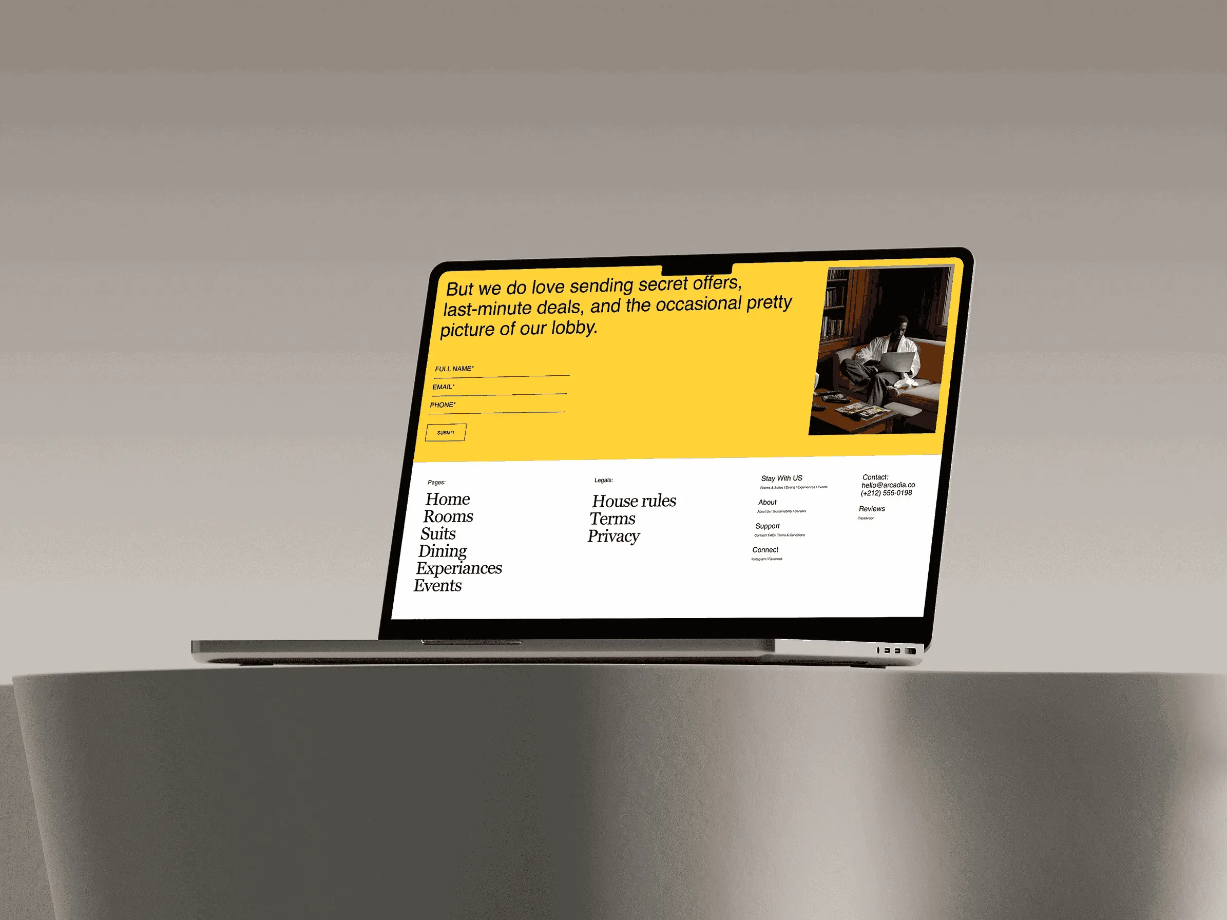 MacBook on beige curved table showing minimal website design