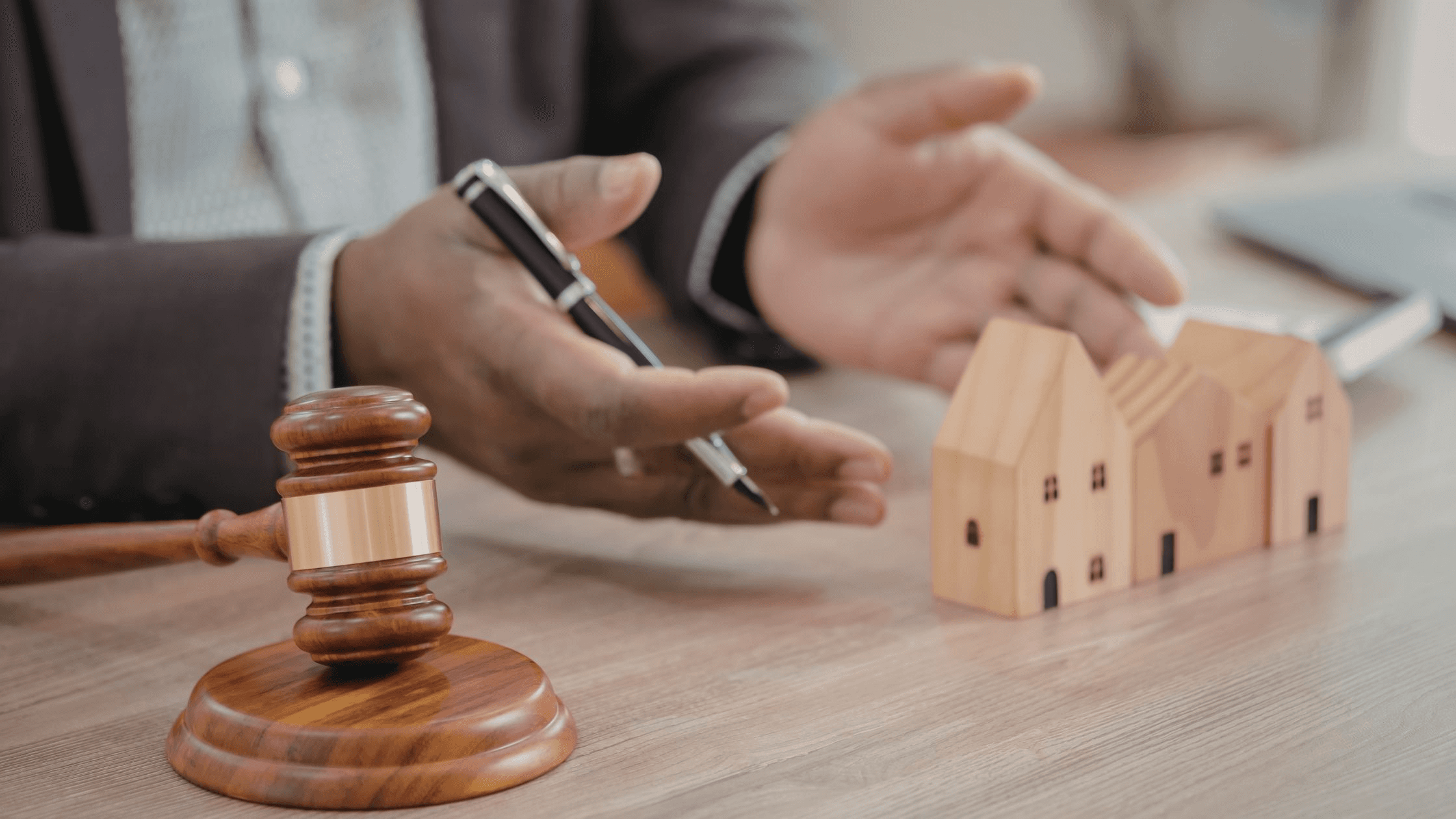 Gavel and wooden houses on desk - Commercial Real Estate Transactions