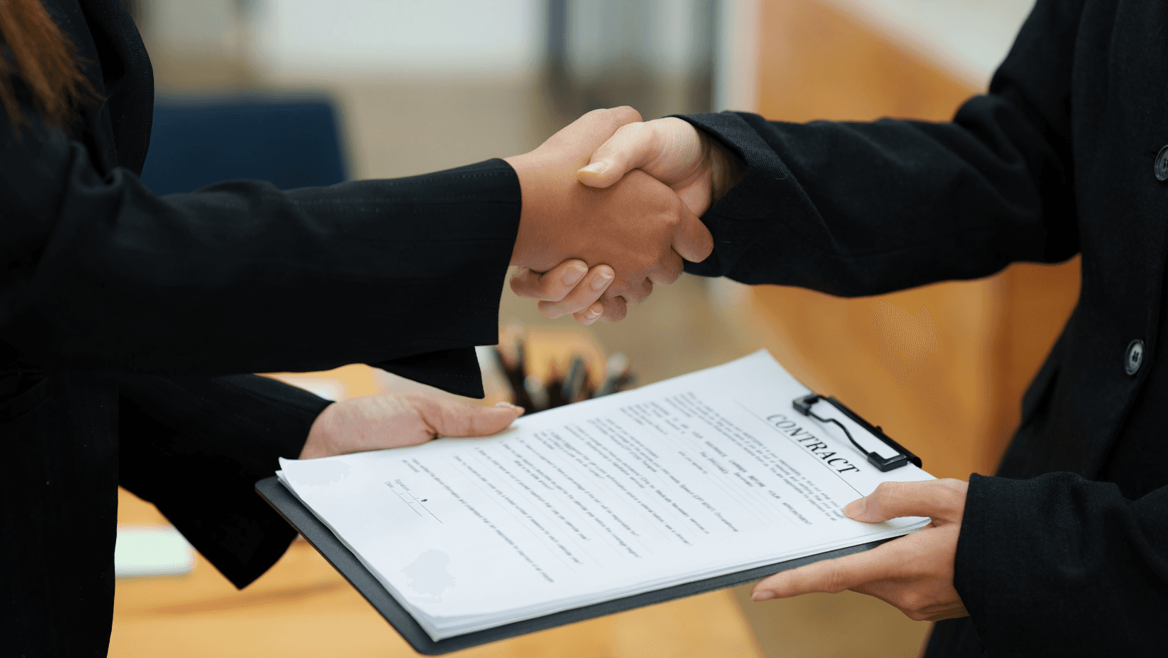 Two people shaking hands over contract - Commercial Real Estate Due Diligence