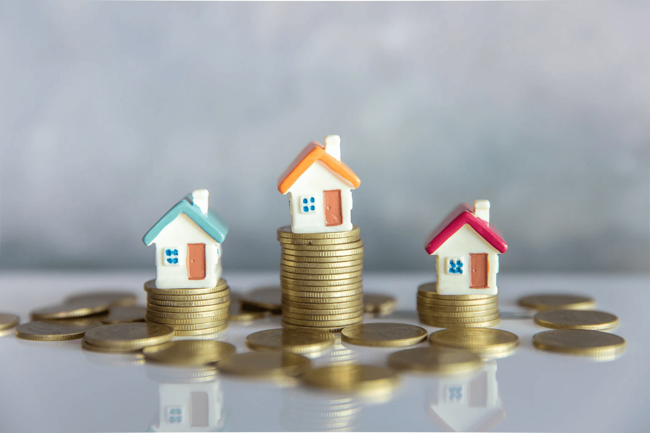 Model houses atop stacks of coins - How to Calculate Cap Rate on Commercial Property