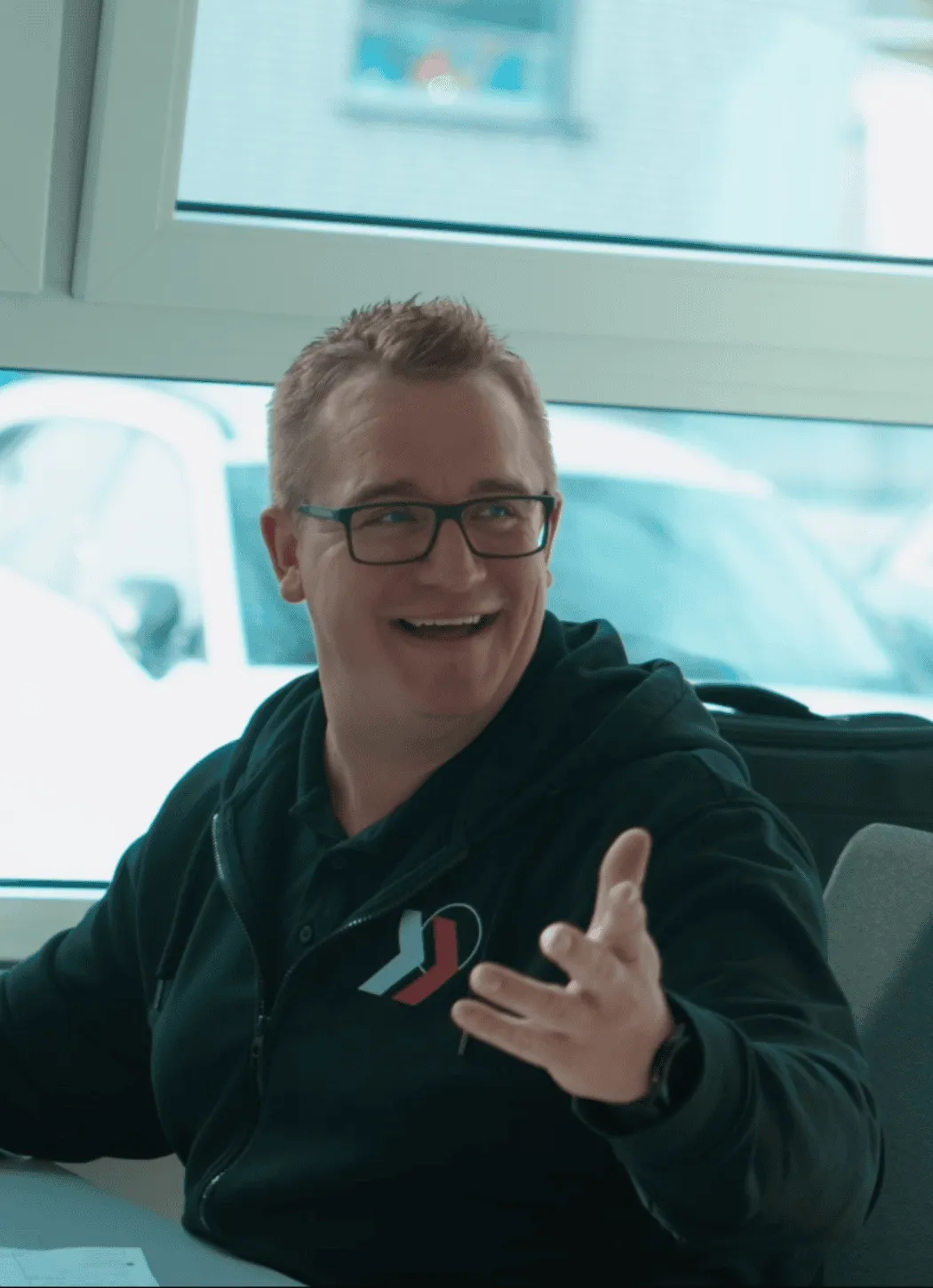 Leitung Fuhrpark der Werner Ruploh Unternehmensgruppe, lächelnd im Büro während eines Gesprächs.