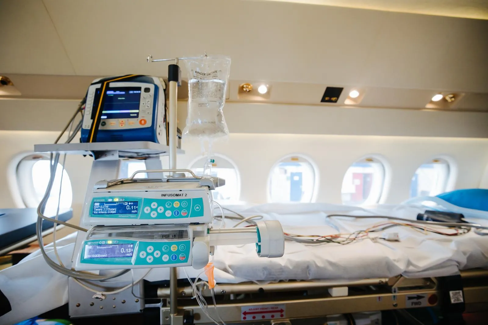Un lit médicalisé avec des moniteurs et une perfusion à bord d'un avion aménagé pour les vols médicalisés.