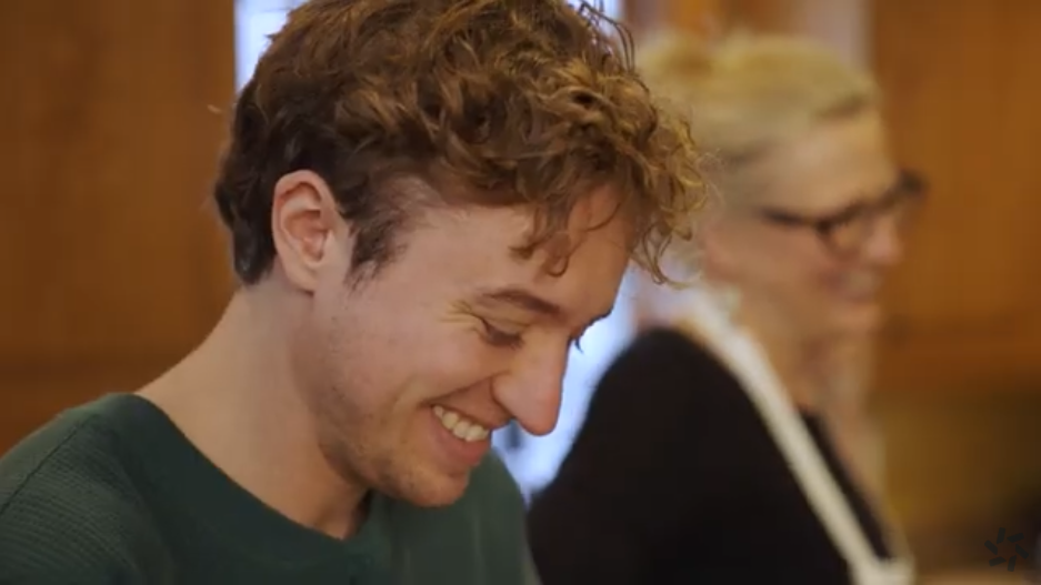 A portrait of Ben looking down and smiling happily