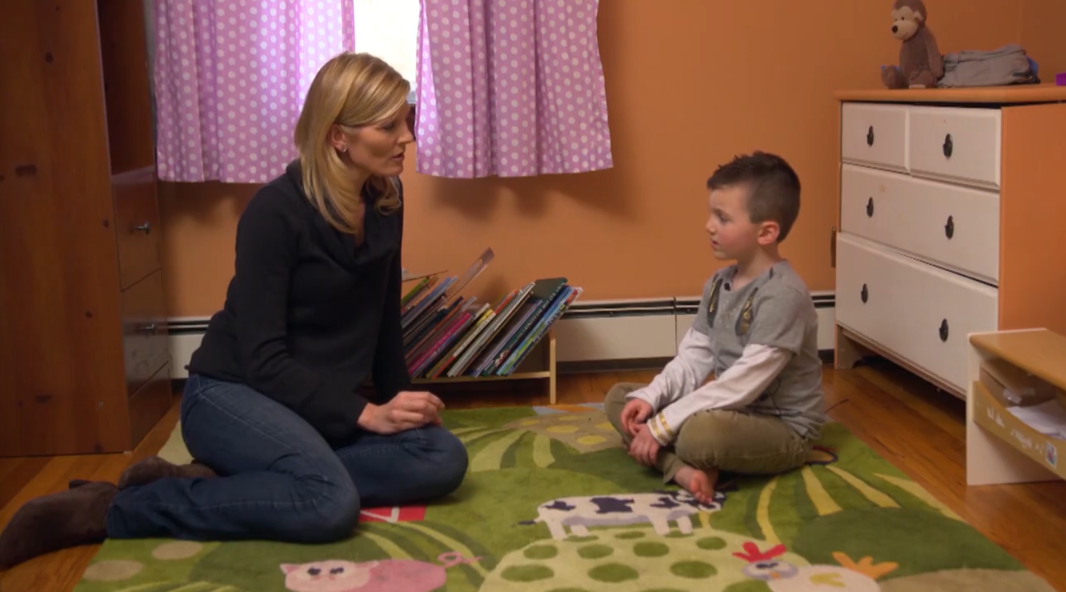 A transgender boy talks with an interviewer in his bedroom
