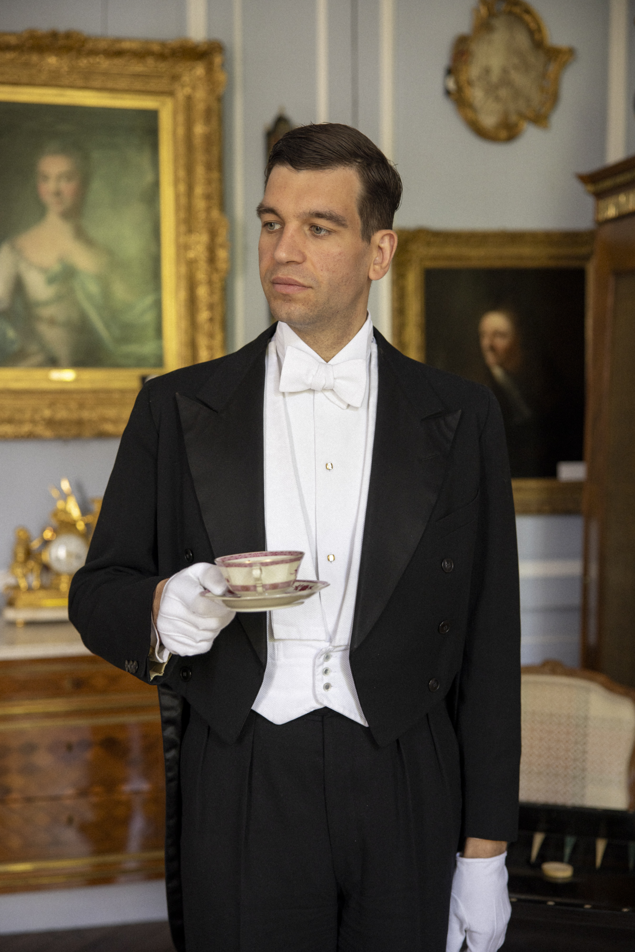 Majordome versant du vin lors d’un dîner d’exception dans un château, mettant en valeur les codes du service à la française et des arts de la table.