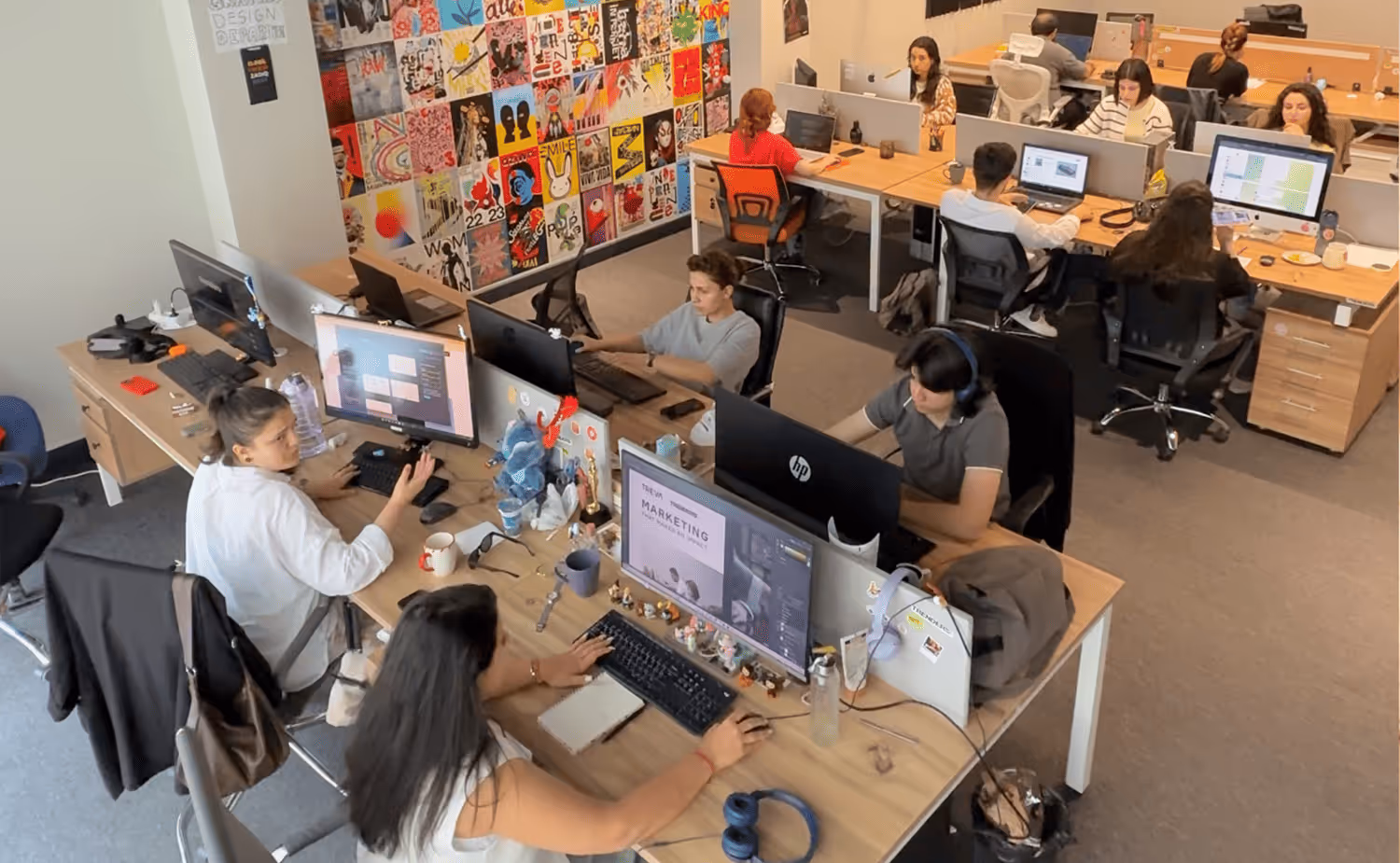A group of people sitting at desks working on computers.