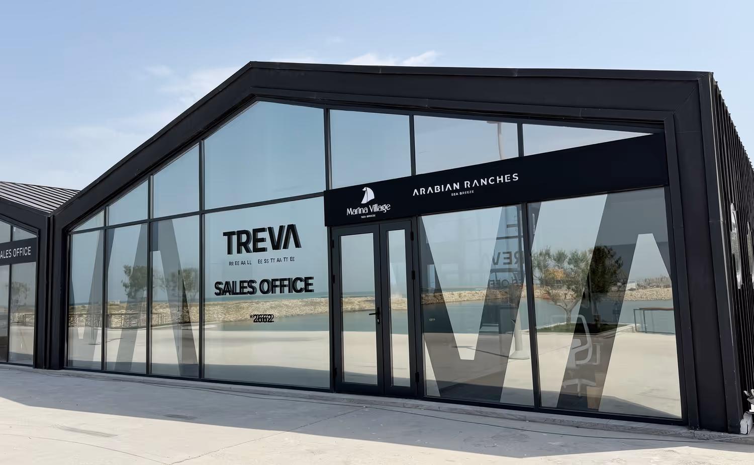 A large glass building with a sign on it.