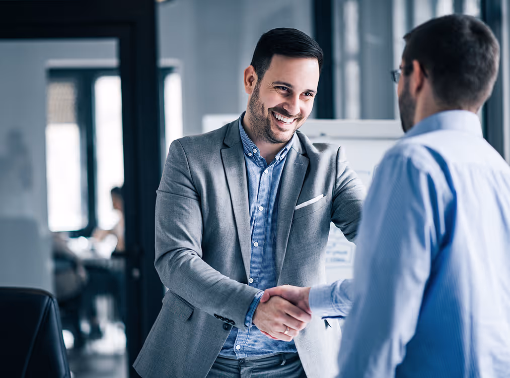 A man shaking hands with another man in a suit.