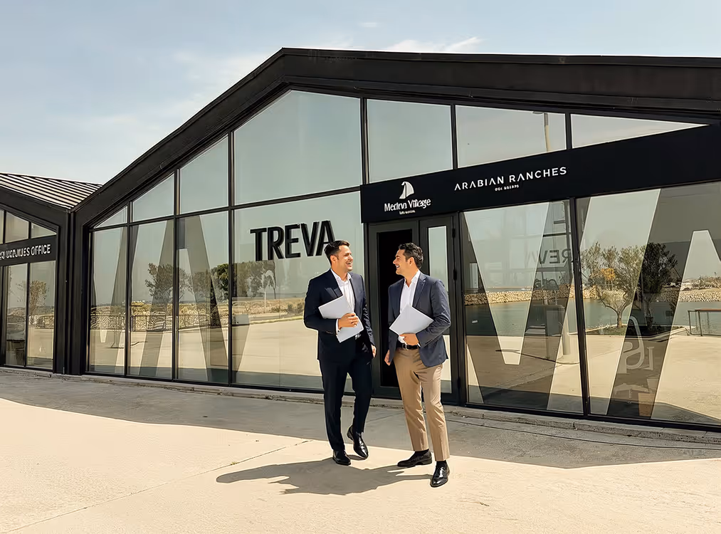 Two men in suits standing outside of a building.
