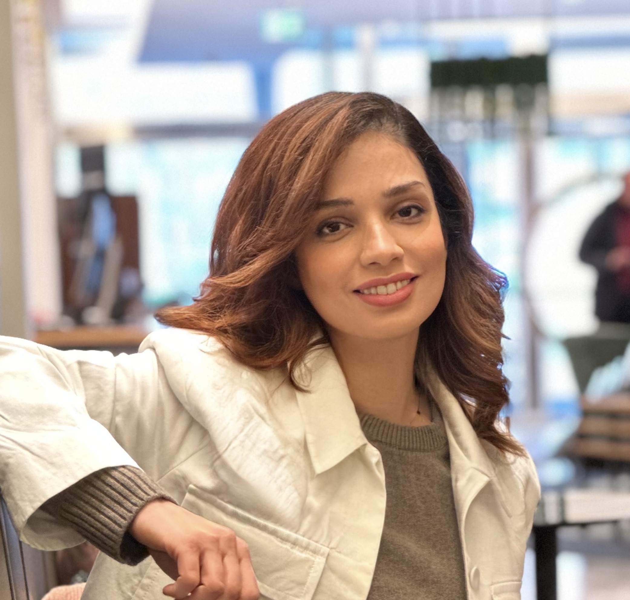 Portrait of Dr Mahsa Yarahmadi, smiling female physician-entrepreneur wearing white blazer.