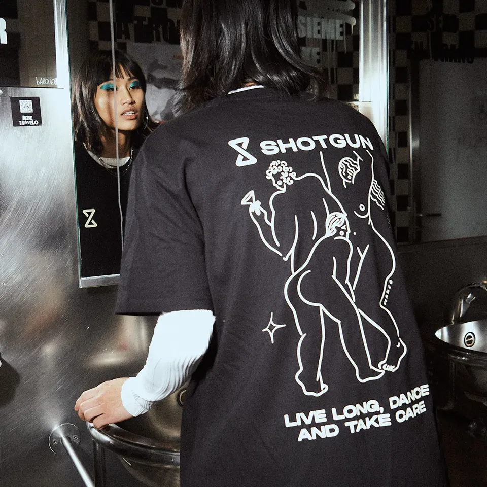 A woman standing in front of a mirror in a bathroom.