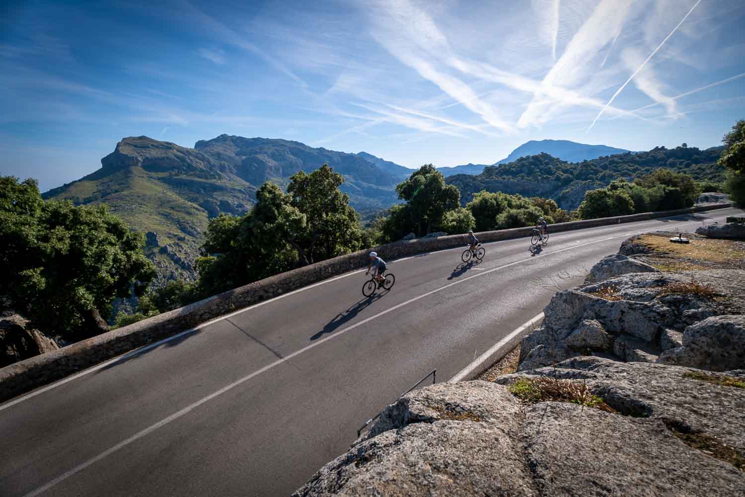 Three Velocamp riders with green mountains behind