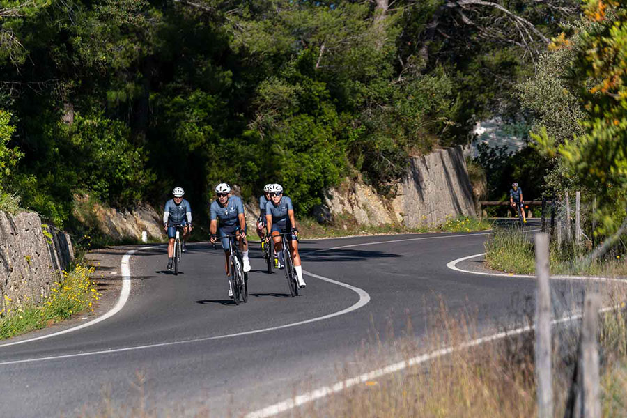 Velocamp Mallorca riders on a quiet lane near Alaró with the Tramuntana mountains in the background