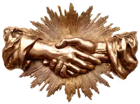 Golden sculpture of two hands shaking with radiant sunburst design in the background.