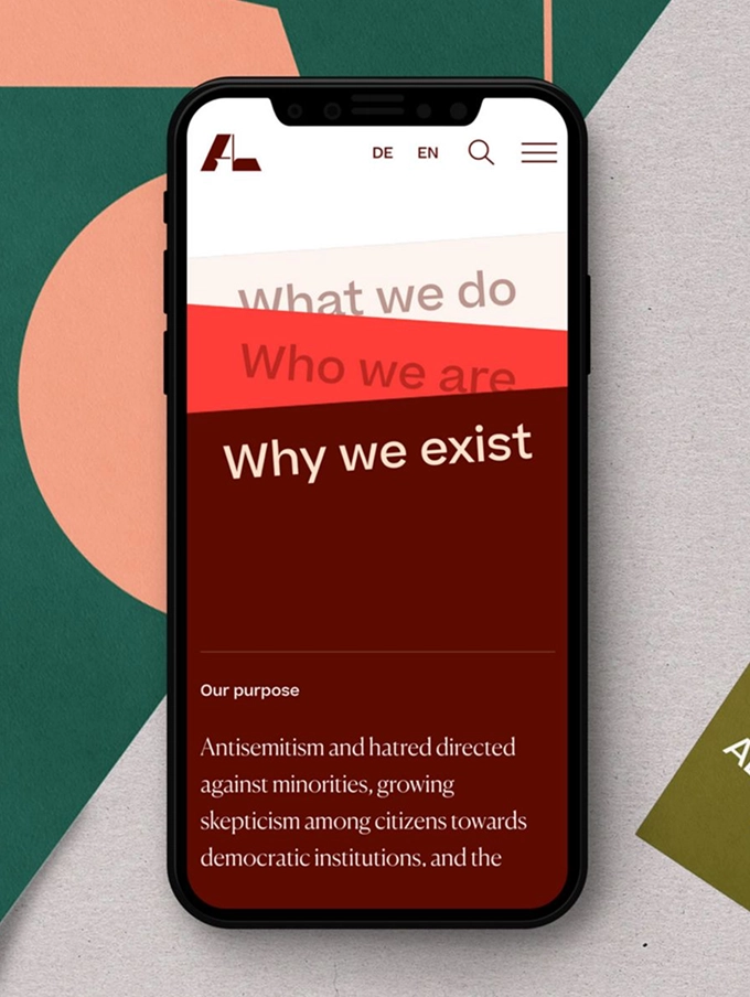 Smartphone displaying a website section titled 'Why we exist' with text about antisemitism and societal skepticism.