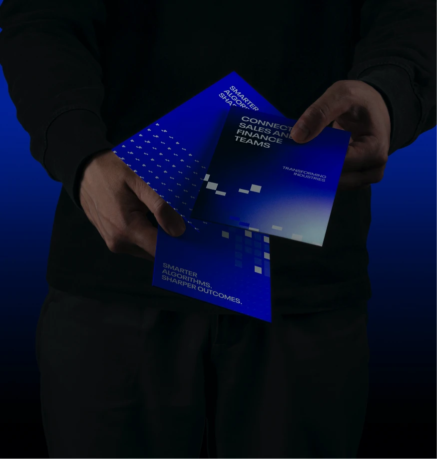 Person holding blue brochures with text about smarter algorithms and connecting sales and finance teams.