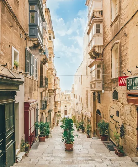 The image depicts a charming street in Valletta, the capital city of Malta. 