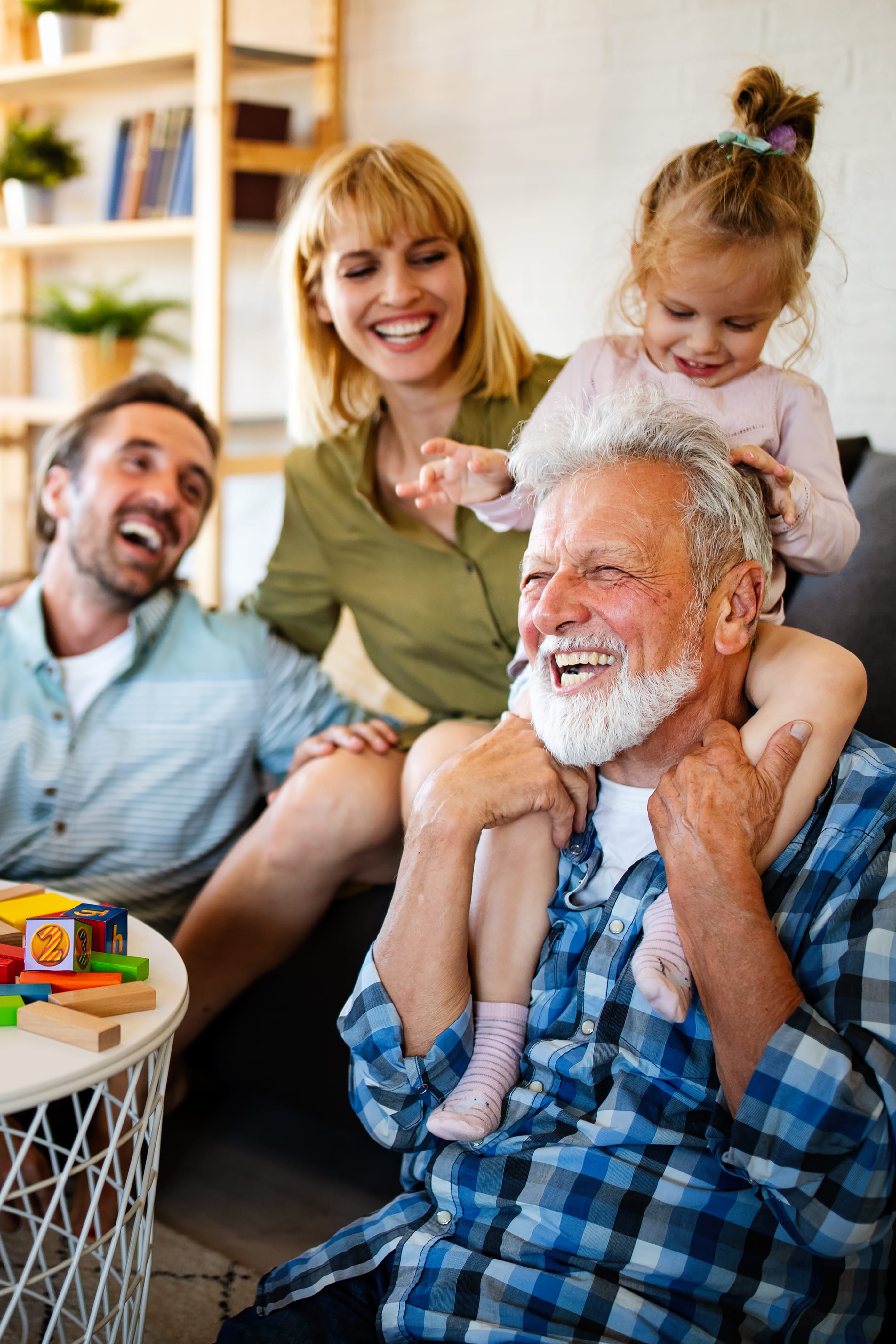 Multi-generational family laughing together in cozy living room