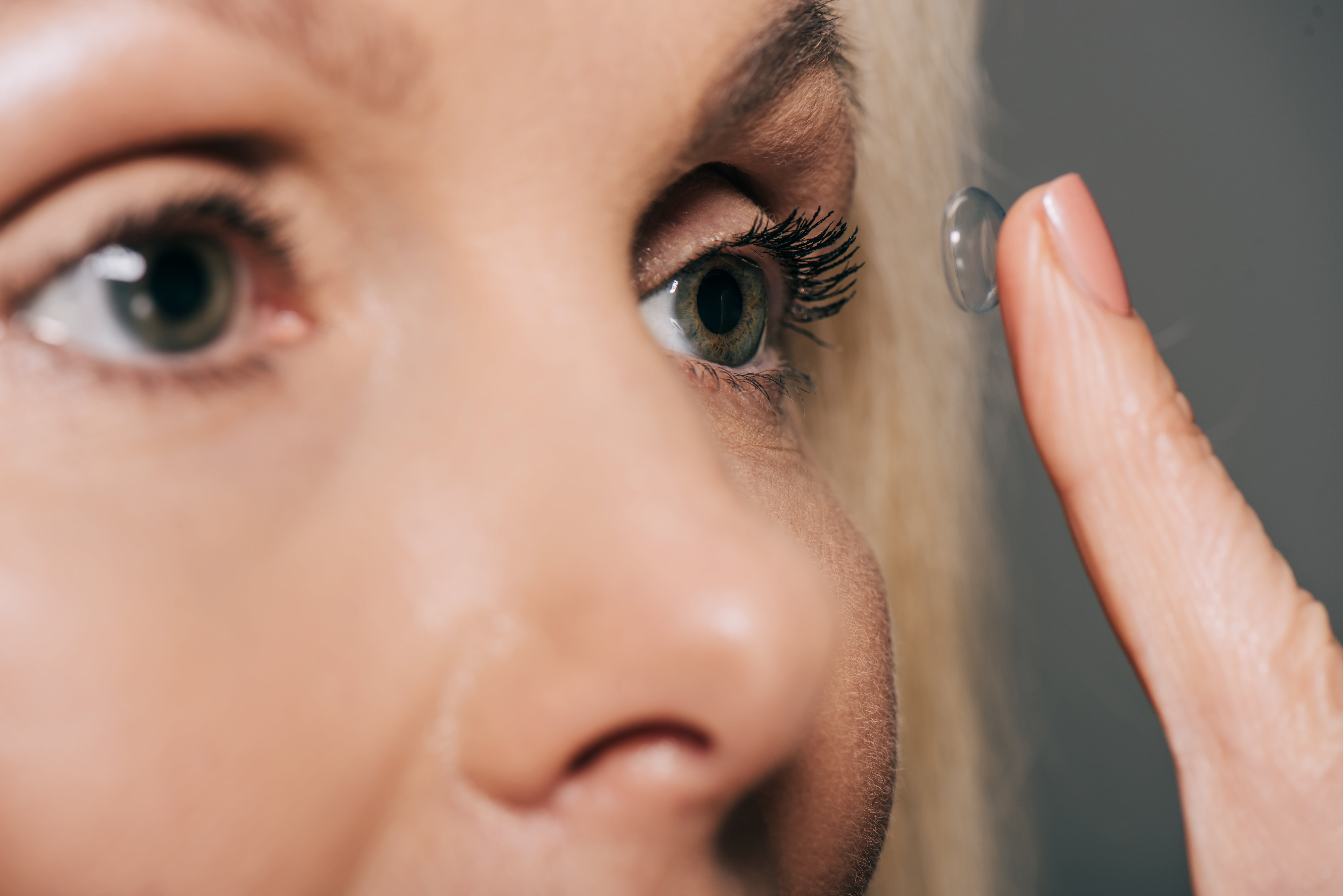 Close-up of eye with contact lens being carefully inserted