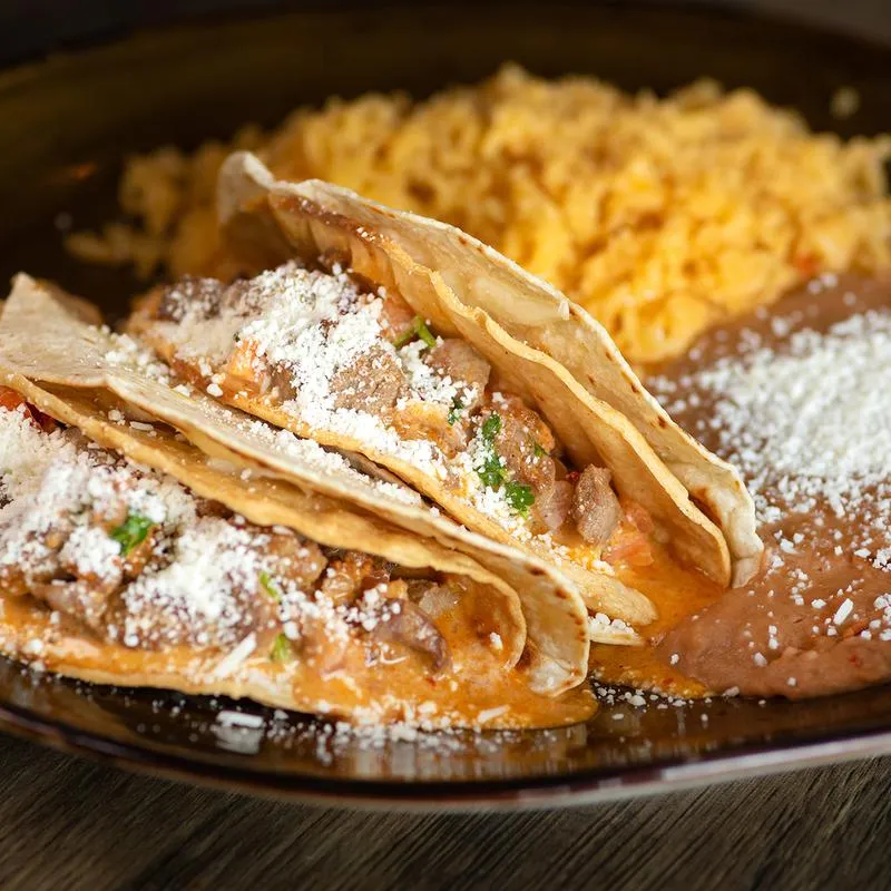 Red enchiladas, Steak fajita tacos, with red tomatoe sauced with beans, chesee and red rice