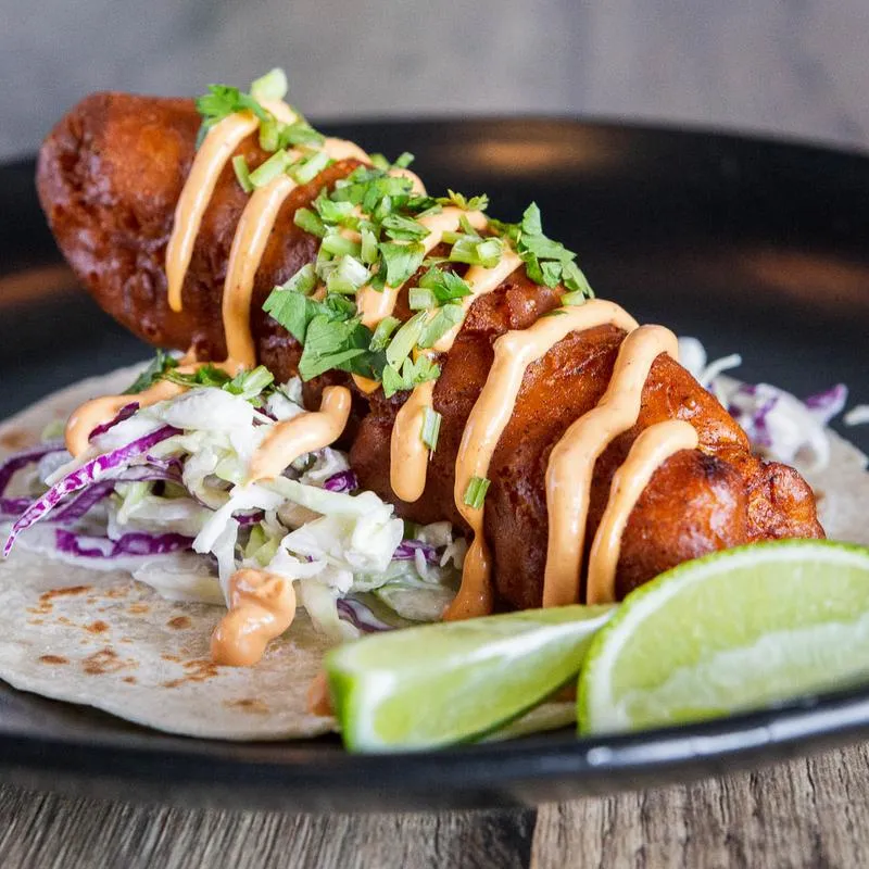 Baja Taco with fried strip of fish, garlic mayo, purple cabash and lemon