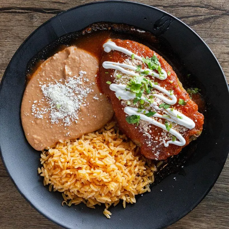 Chile relleno with cheese, beans and red rice dish