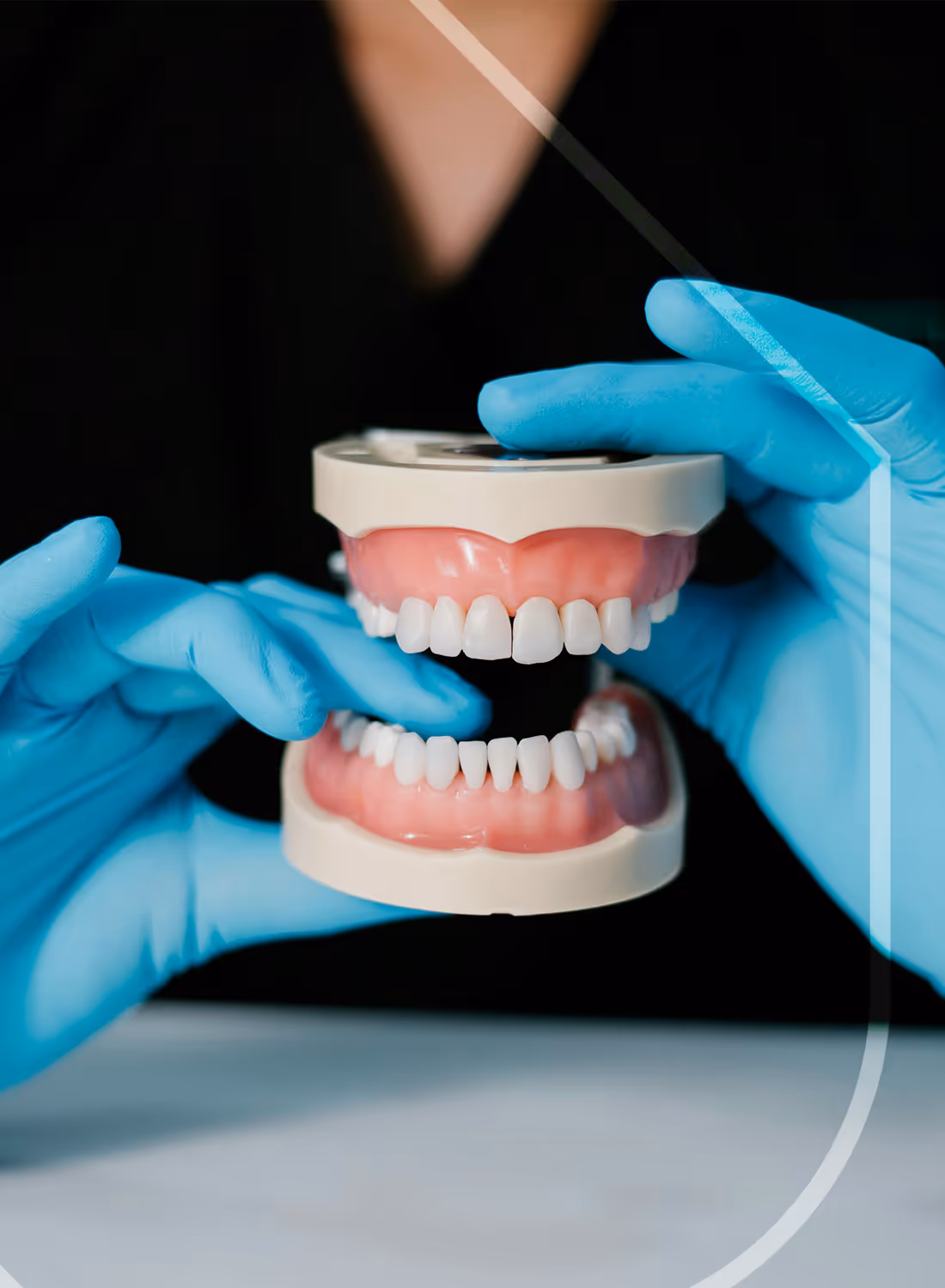 Denturologiste présentant une paire de prothèses complètes