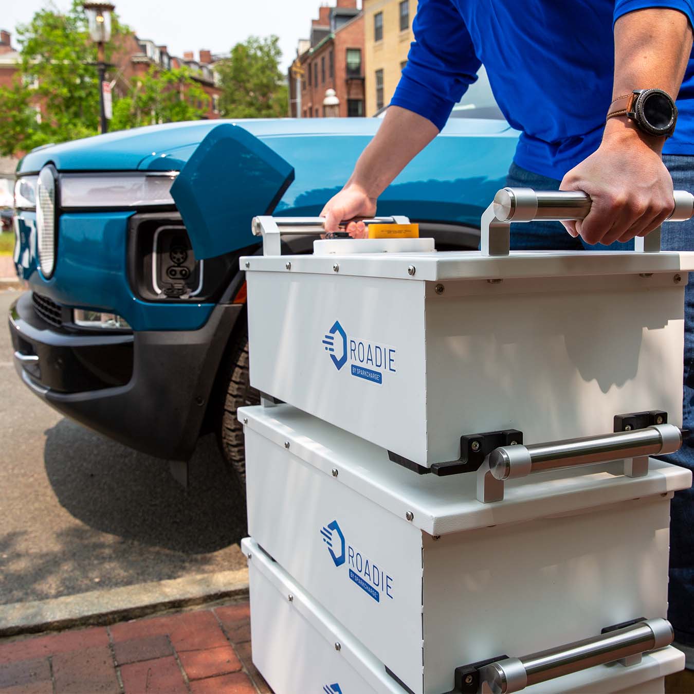 a mobile EV charging technician stacking the Roadie Portable EV charger together to deliver mobile DC fast charging to a Rivian R1T
