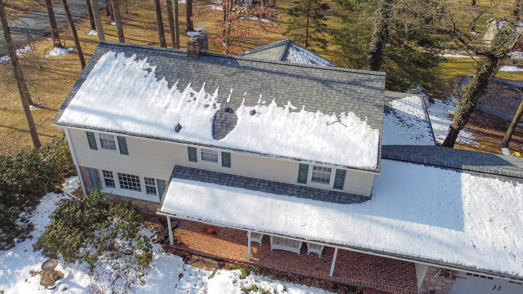 Partially melted snow on a roof that may need to be removed