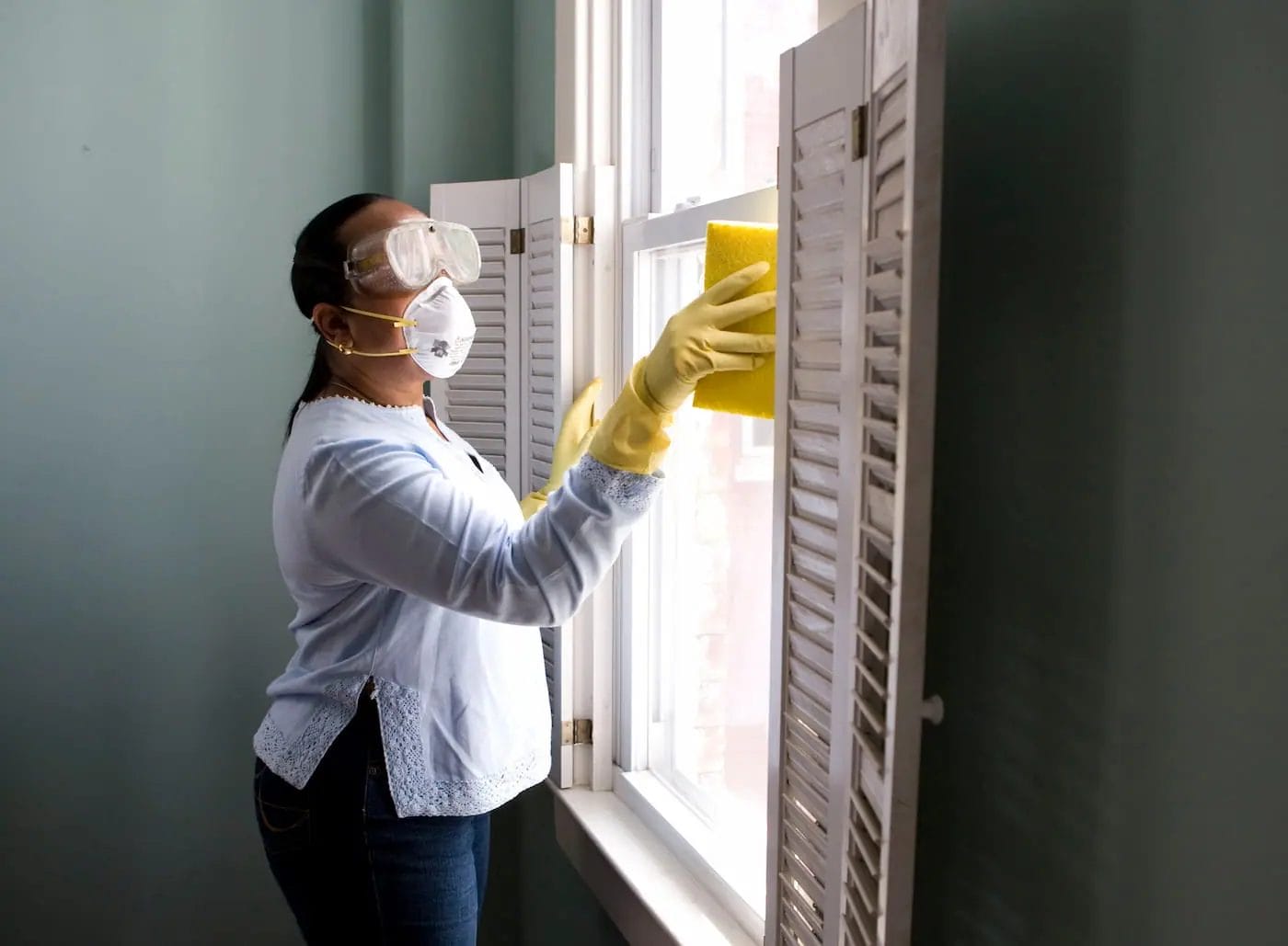 Woman cleaning mold off of window sills