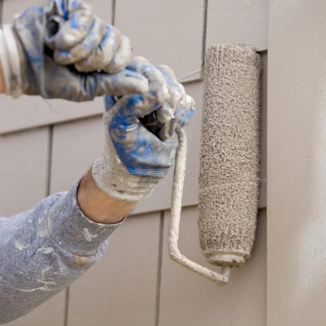 Should You Paint Your Siding? A Man Paints His Siding with a roller.