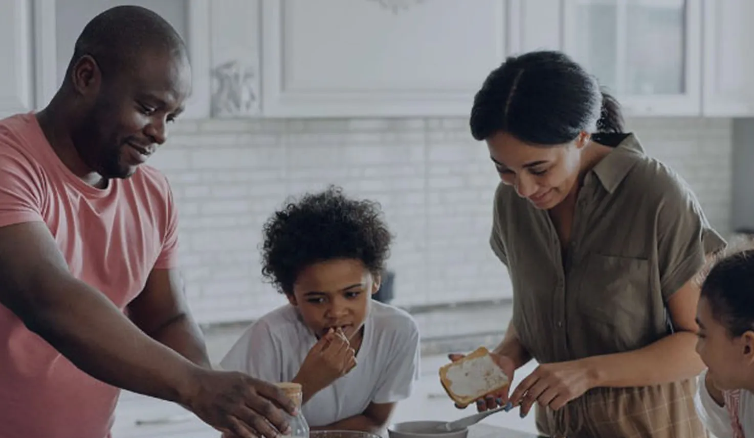 Smiling parents and children preparing breakfast together in a bright kitchen