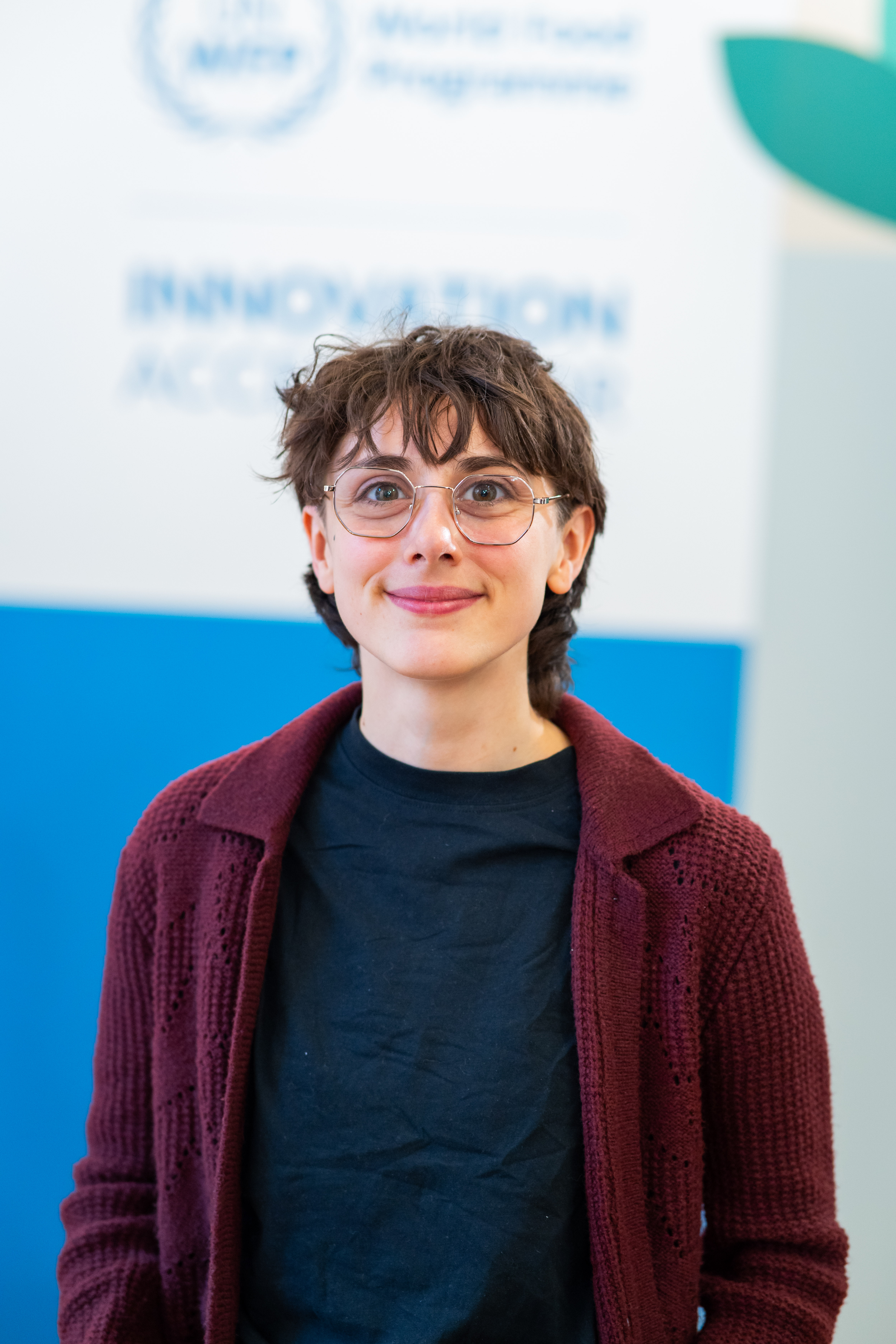 Photograph of Carita Marsili smiling in front of a blue wall with the WFP logo.