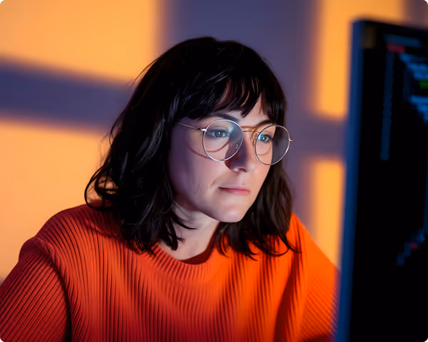 Fachkraft am Bildschirm in technischer Umgebung, repräsentiert das interdisziplinäre Team von eges für Messtechnik und Abrechnung