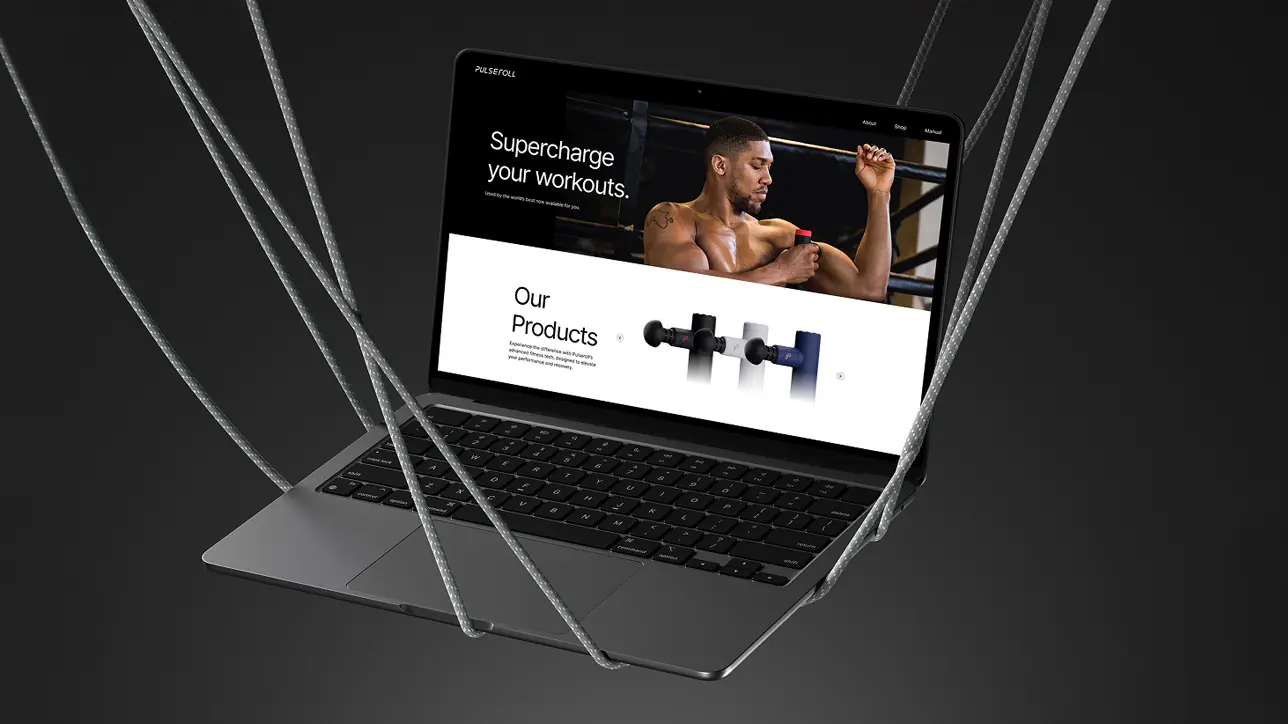 Floating MacBook Pro mockup suspended by ropes, displaying the high-fidelity e-commerce landing page design for the Anthony Joshua x Pulseroll campaign