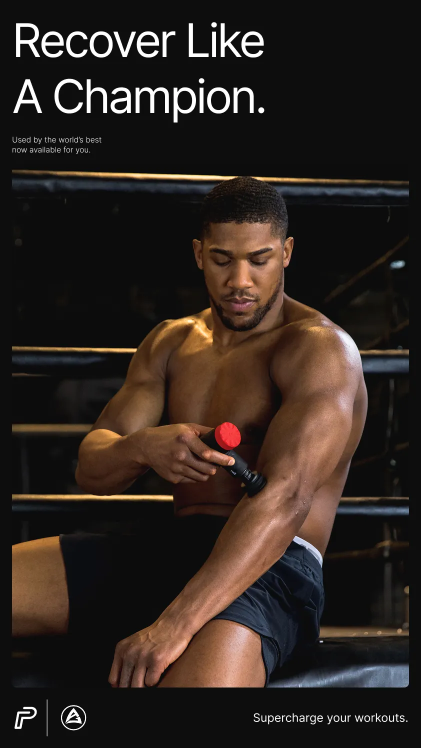 Anthony Joshua using the Pulseroll massage gun on his arm, demonstrating the product's muscle recovery features in a gym setting