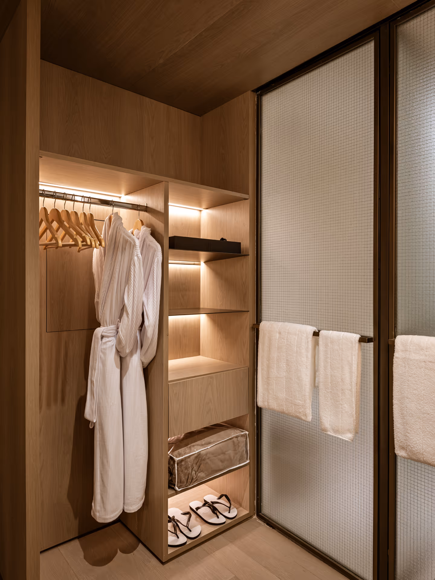 Cozy luxurious closet interior features plush robes, soft towels, and warm slippers perfectly.