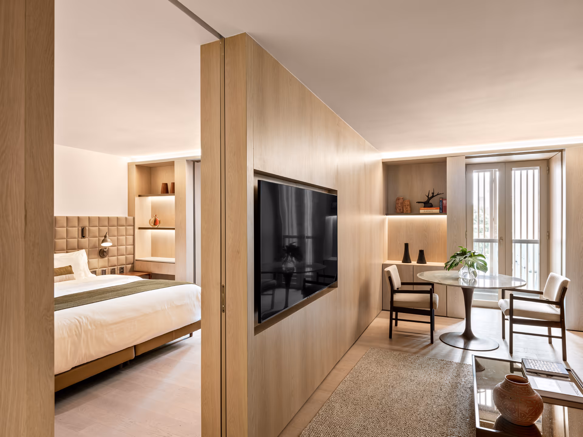 Luxurious modern hotel accommodations featuring comfortable bedding, natural light, and premium entertainment options.