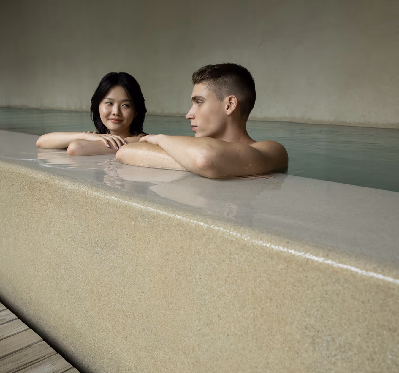 Couple relaxing in a serene indoor pool setting amidst calming luxury atmosphere together peacefully