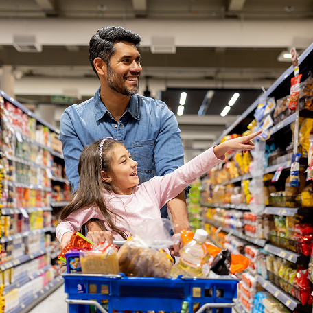 A father and daughter grocery shopping together at a grocery store.