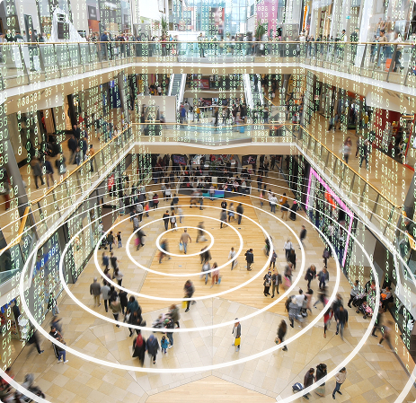 Crowded modern multi-level shopping mall with concentric circles and code overlay suggesting digital data.